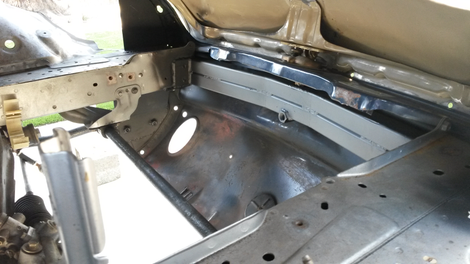 Inside of the new front engine bay of the car, looking at the front crash bar under the hood.